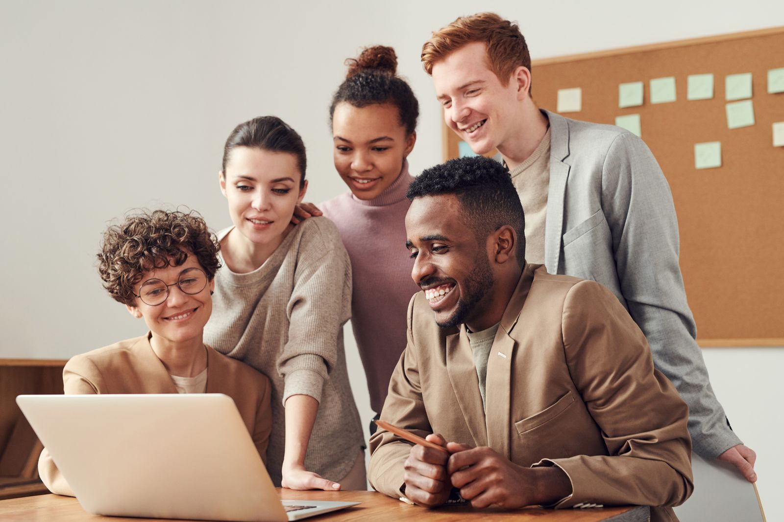 A small team of professionals collaborating around a laptop while planning a website project