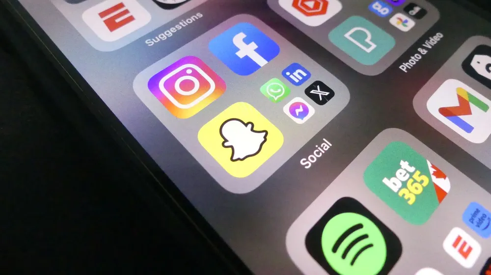 A smartphone home screen showing a folder of social media apps — platforms you rent, not own