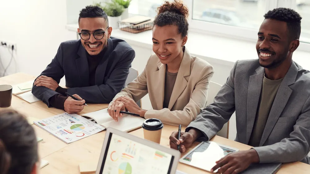 Happy clients smiling together in a meeting, the kind of trust your website needs to convey