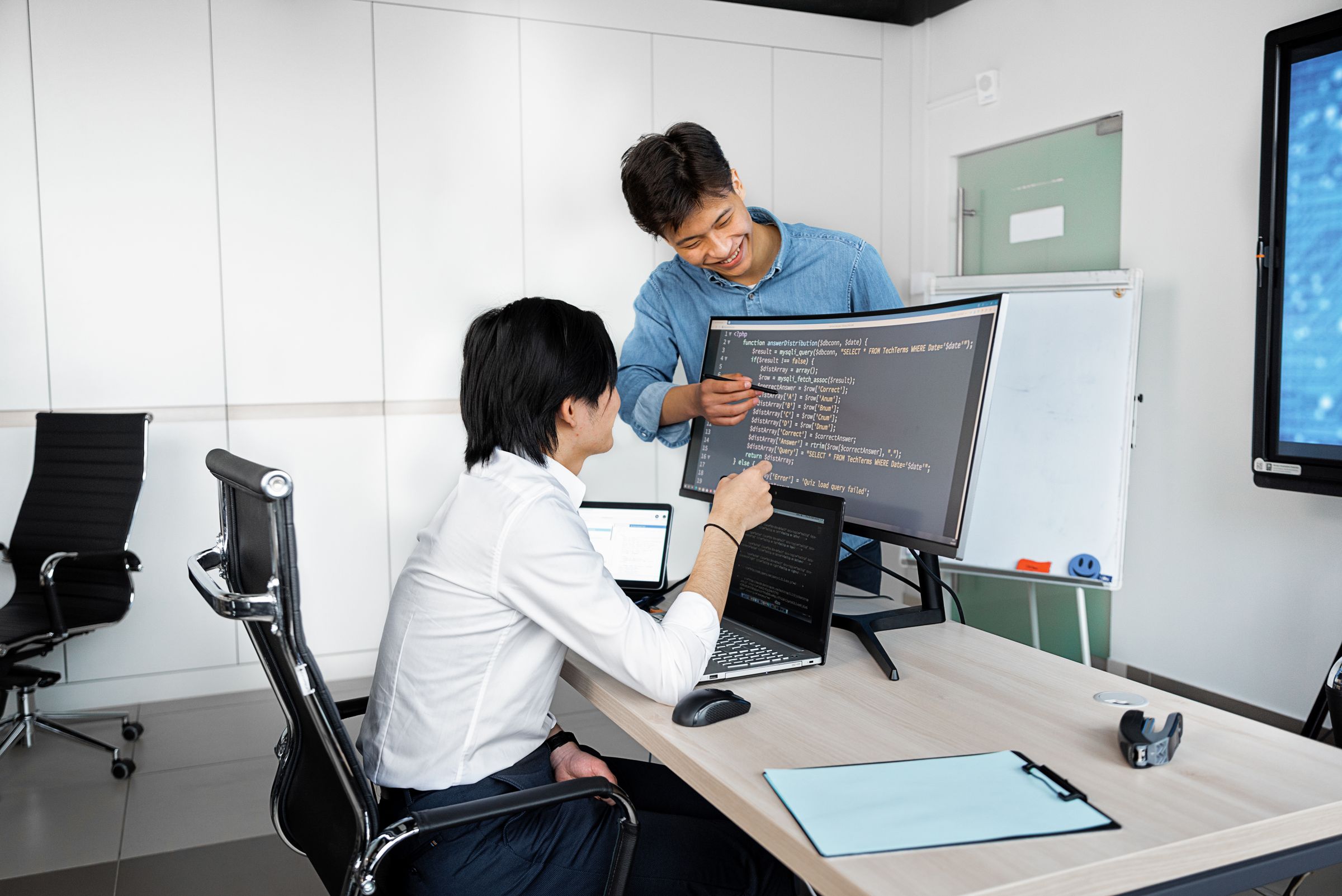 Two professionals reviewing a developer's portfolio and past work on laptops