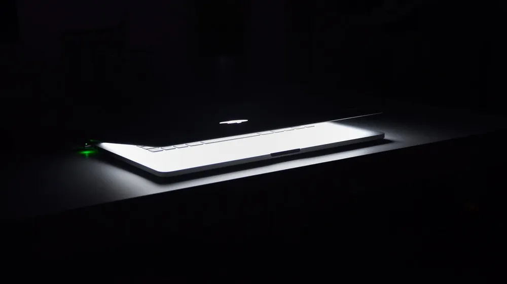 A laptop glowing in a dark room — a website quietly working while you sleep